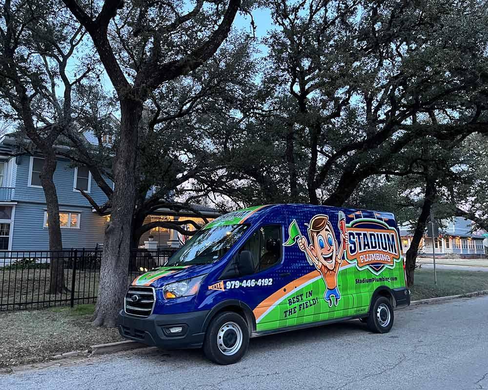 plumbers company van at residential property exteriors college station tx